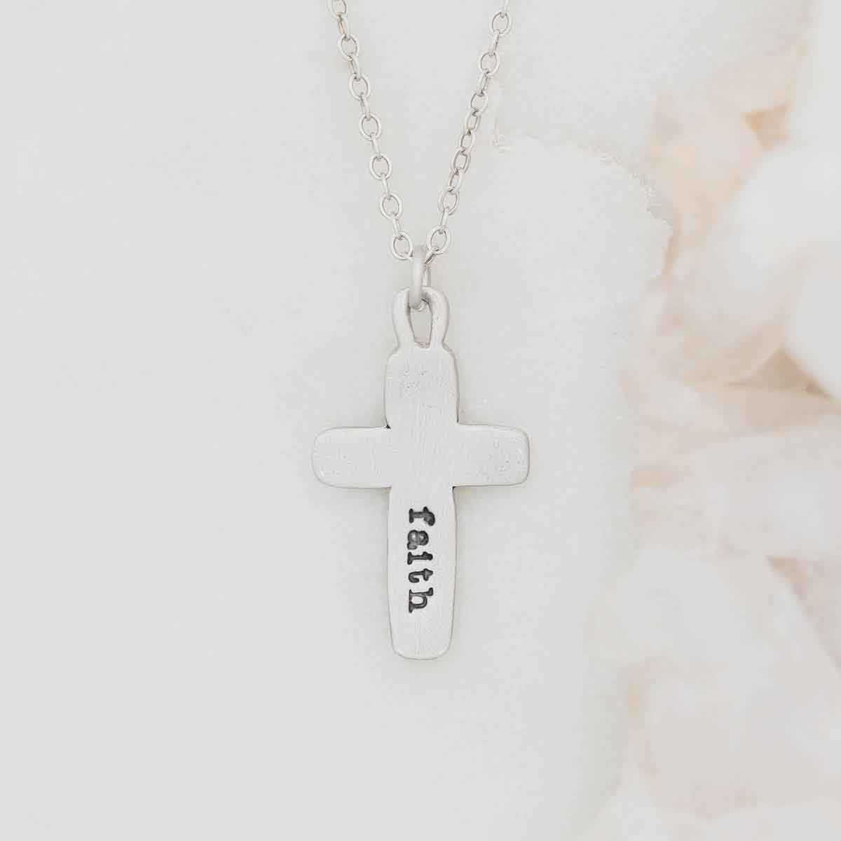 Handcrafted sterling silver cross of faith necklace strung on a sterling silver link chain with "faith" stamped on the back