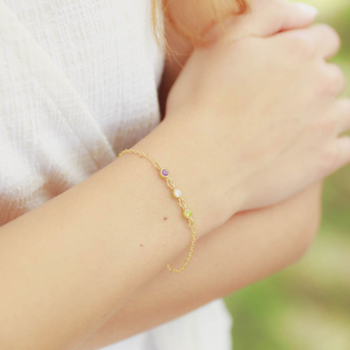 girl wearing 10k yellow gold Dainty Finespun Birthstone Bracelet - Medium personalized with 3mm birthstones