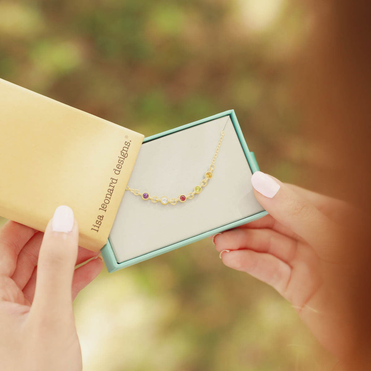 girl holding 10k yellow gold Dainty Finespun Birthstone Bracelet - Medium personalized with 3mm birthstones