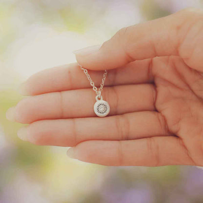 girl holding a Dainty Sunburst Necklace cast in Sterling Silver and set with a 3mm cubic zirconia stone