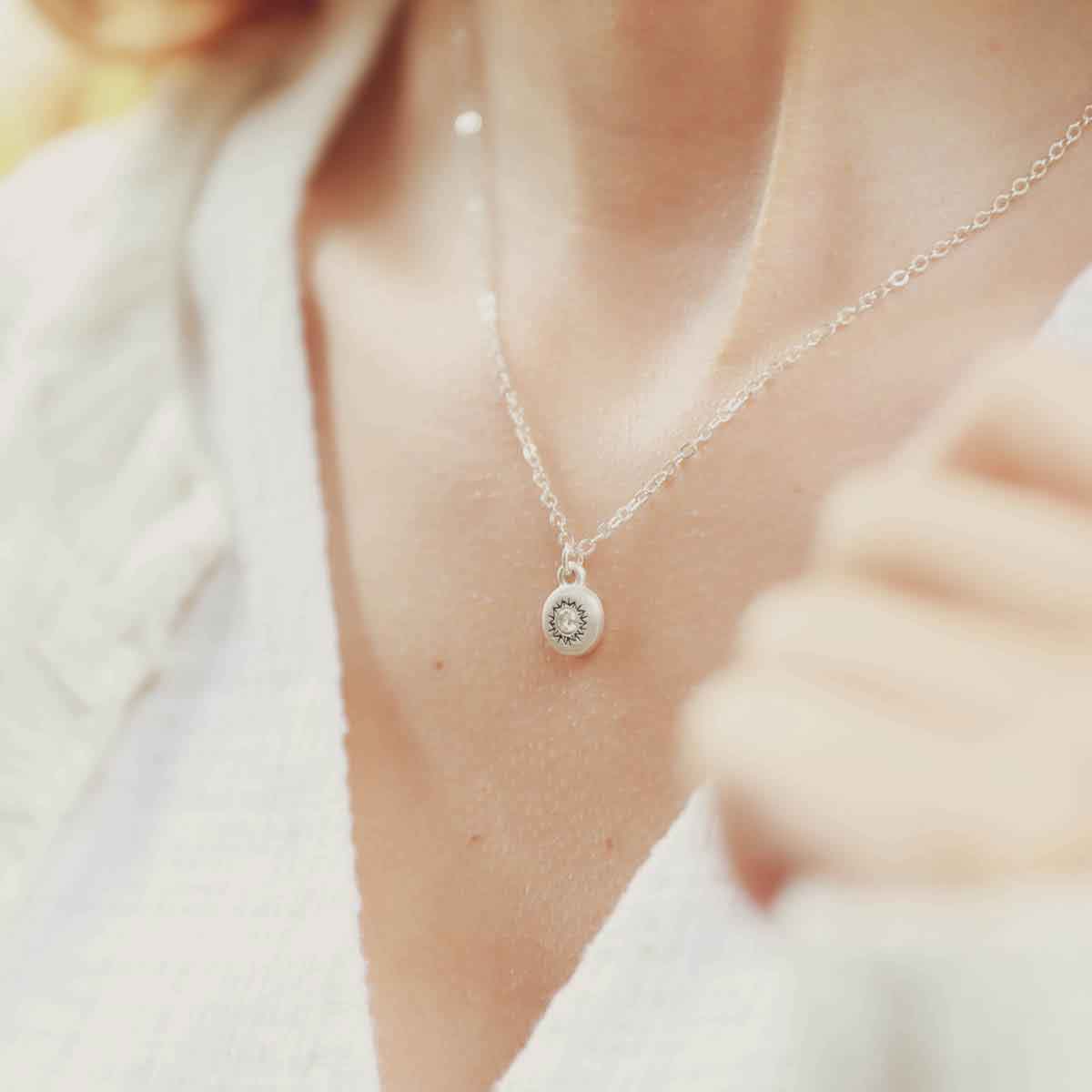 girl wearing a Dainty Sunburst Necklace cast in Sterling Silver and set with a 3mm cubic zirconia stone