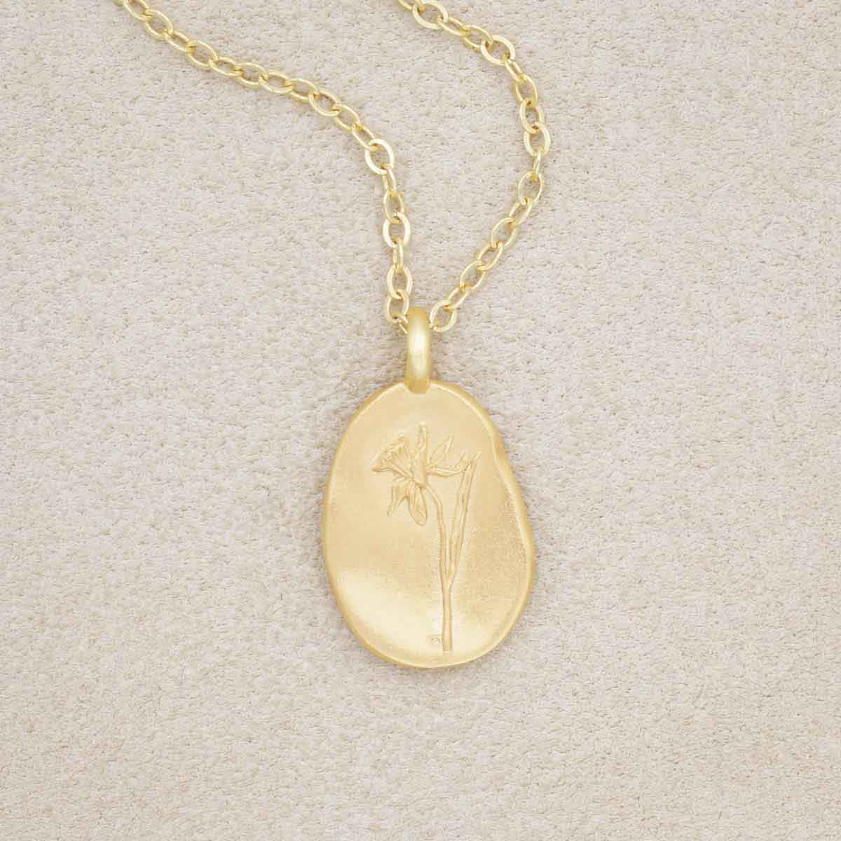 gold plated December birth flower necklace with an 18" gold filled link chain, on beige background