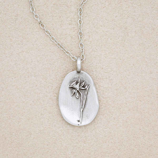 a pewter December birth flower necklace with an 18" link chain, on a beige background