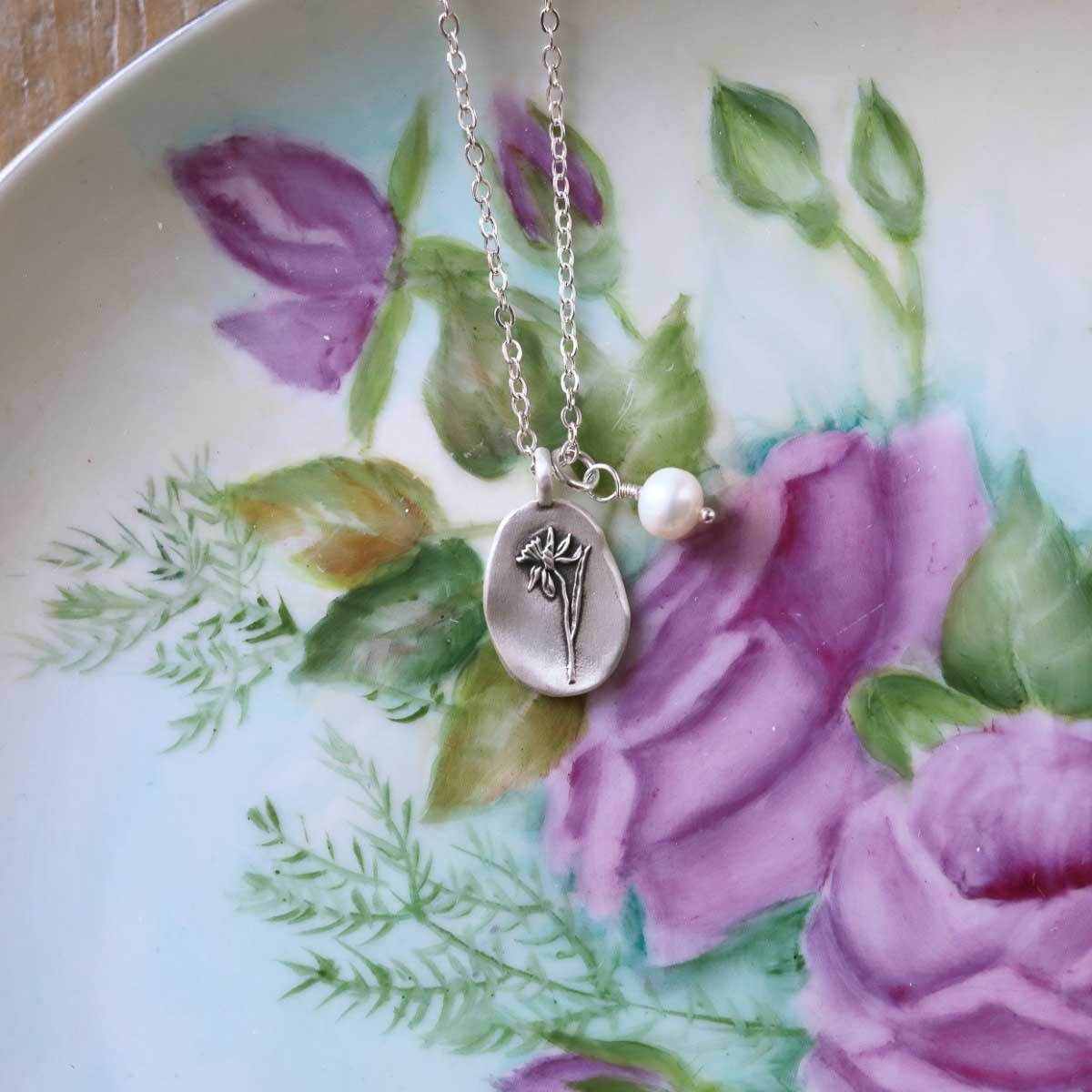 December birth flower necklace handcrafted in sterling silver with a special birth month charm strung with a vintage freshwater pearl