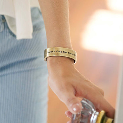 Girl wearing engraved artisan bronze-plated pewter deeper than the ocean cuff bracelet