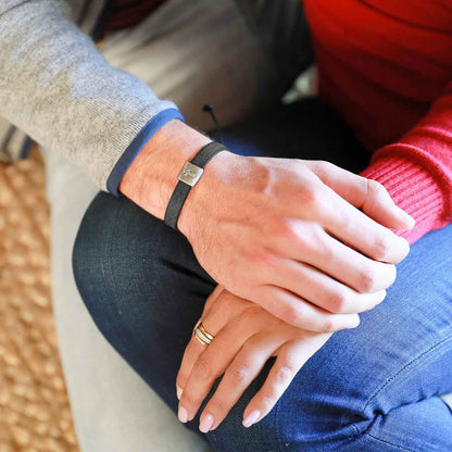 Man wearing Equitable Leather Cross bracelet handcrafted in black latigo leather with a pewter bead with girlfriend wearing other sterling silver jewelry