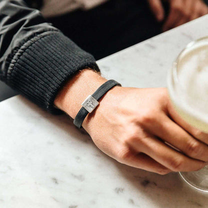 Man wearing Equitable Leather Cross bracelet handcrafted in black latigo leather with a pewter bead