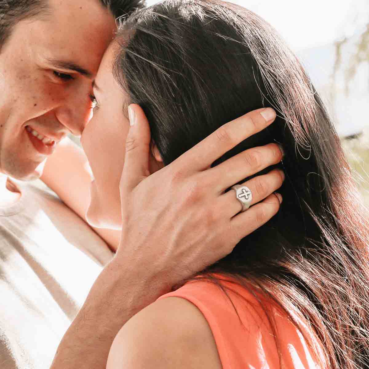 Man wearing Faith Hope and Love Cross Signet ring handcrafted in sterling silver with an antiqued finish with his girlfriend