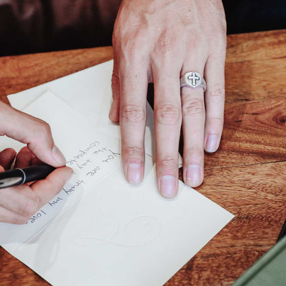 Man wearing Faith Hope and Love Cross Signet ring handcrafted in sterling silver with an antiqued finish 