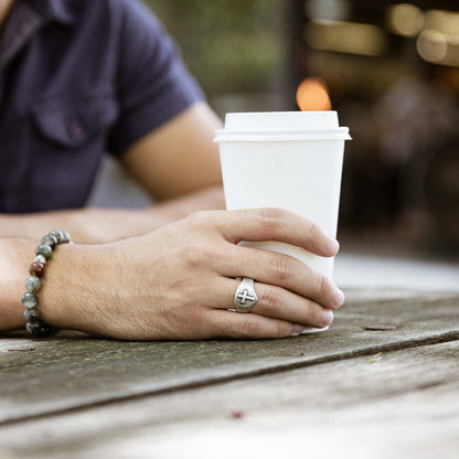 Man wearing Faith Hope and Love Cross Signet ring handcrafted in sterling silver with an antiqued finish along with other SDL products