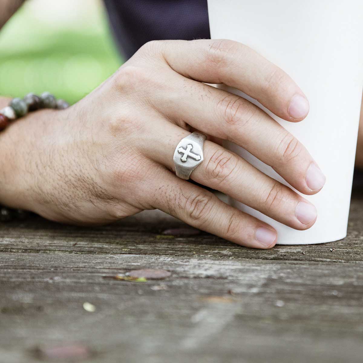 Man wearing Faith Hope and Love Cross Signet ring handcrafted in sterling silver with an antiqued finish