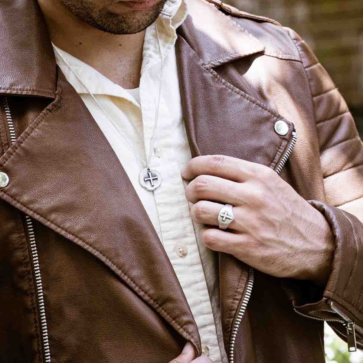 Man wearing Faith Hope and Love Cross Signet ring handcrafted in sterling silver with an antiqued finish along with other sterling silver jewelry