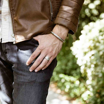 Man wearing Faith Hope and Love Cross Signet ring handcrafted in sterling silver with an antiqued finish along with other sterling silver jewelry