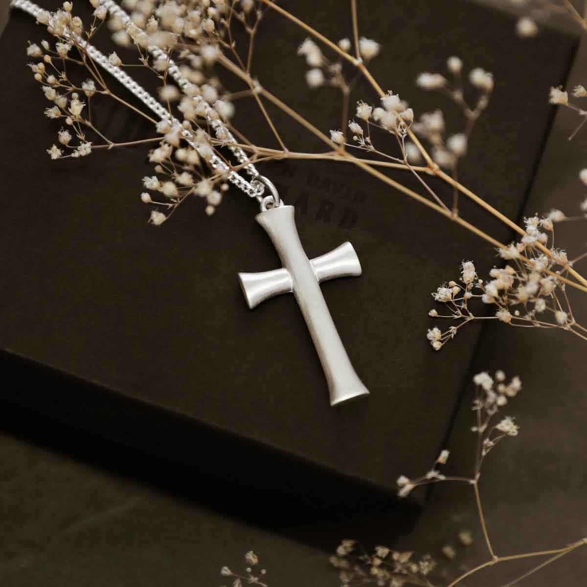 man holding a sterling silver Faith Through Love Cross Necklace