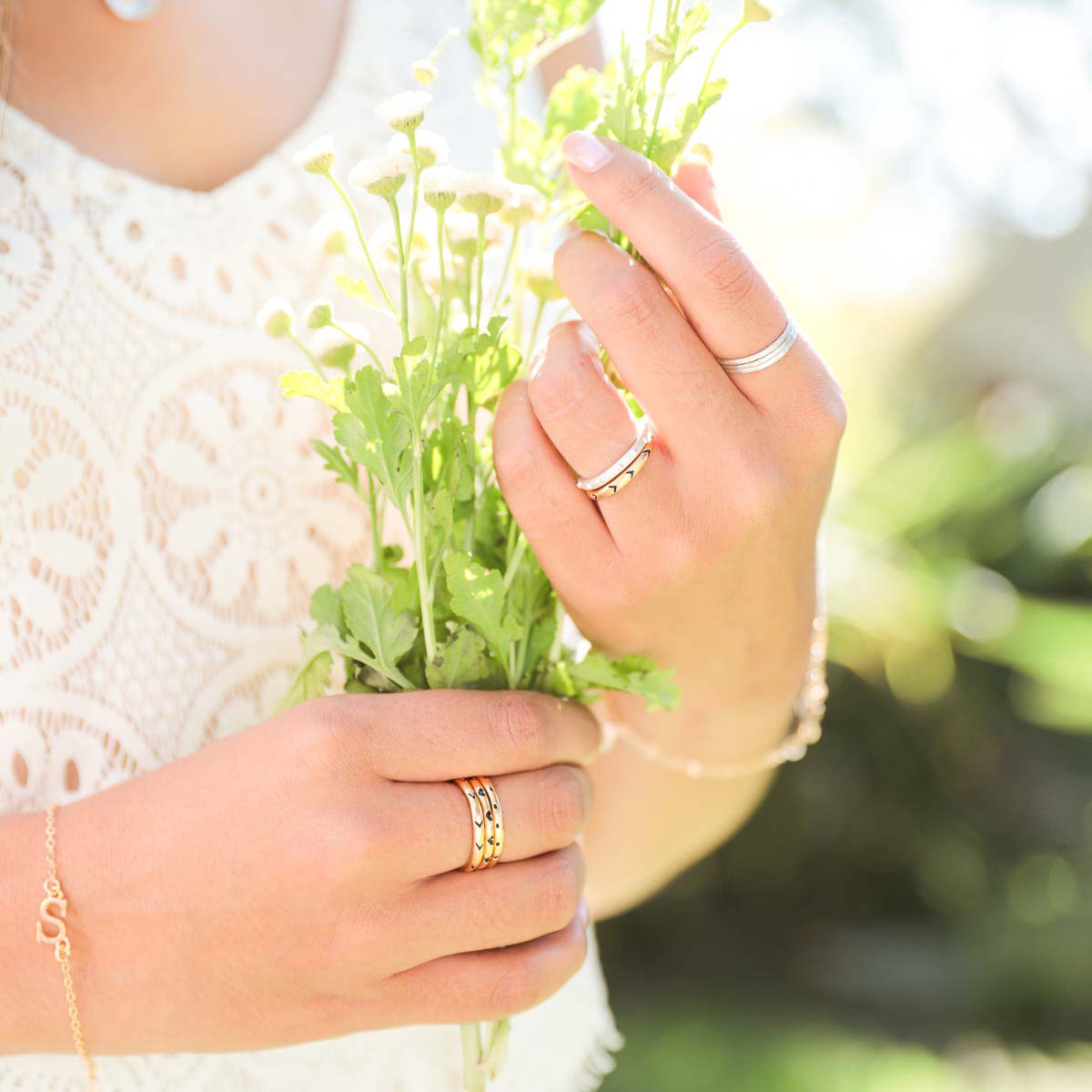 Girl wearing Featherweight stacking rings with 3 stackable ring handcrafted in sterling silver along with other sterling silver designs