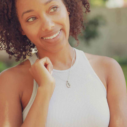 girl holding a sterling silver February birth flower necklace