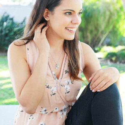 Girl wearing her February birth flower necklace handcrafted in sterling silver with a special birth month charm strung with a vintage freshwater pearl