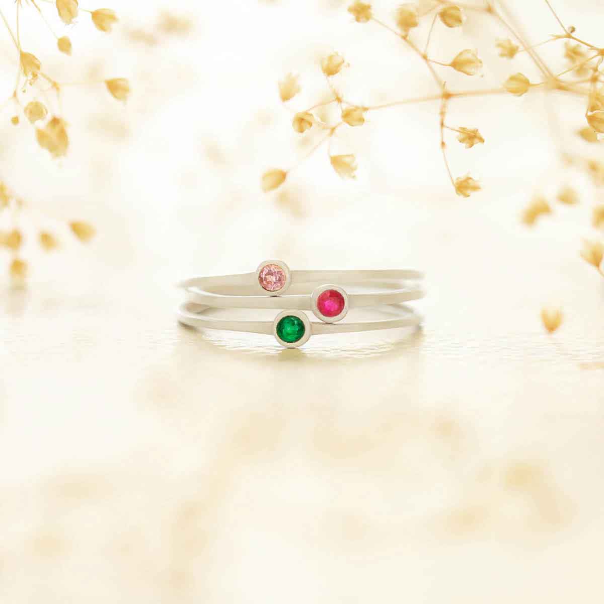 girl holding trio set of sterling silver Dainty finespun birthstone rings in a lisa leonard box