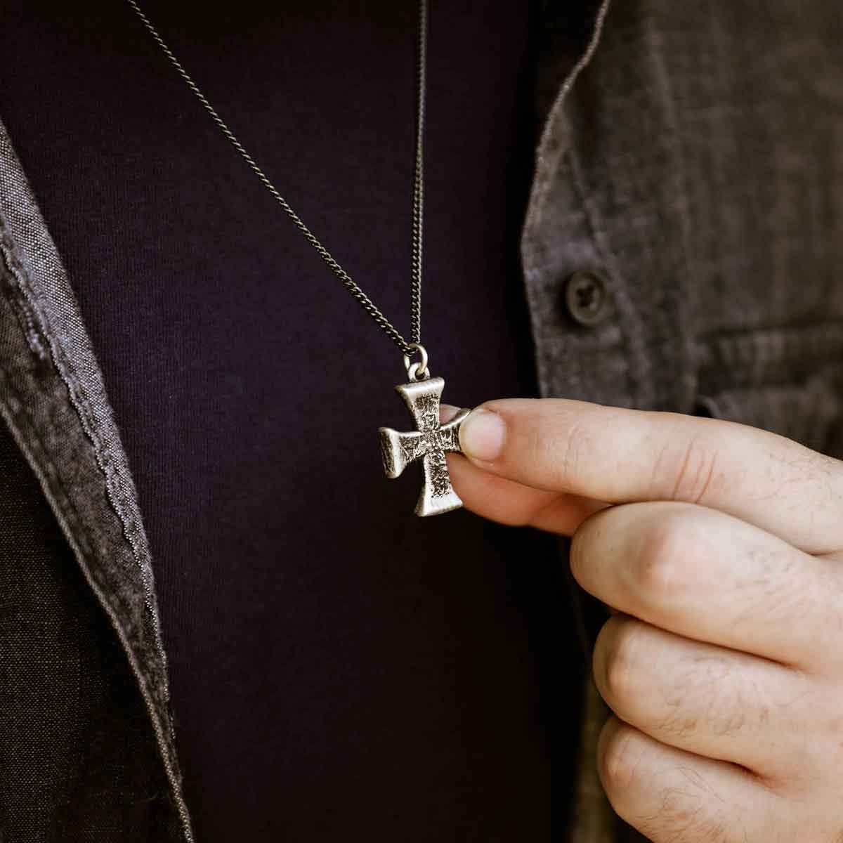 man wearing a sterling silver Flourish Cross Necklace