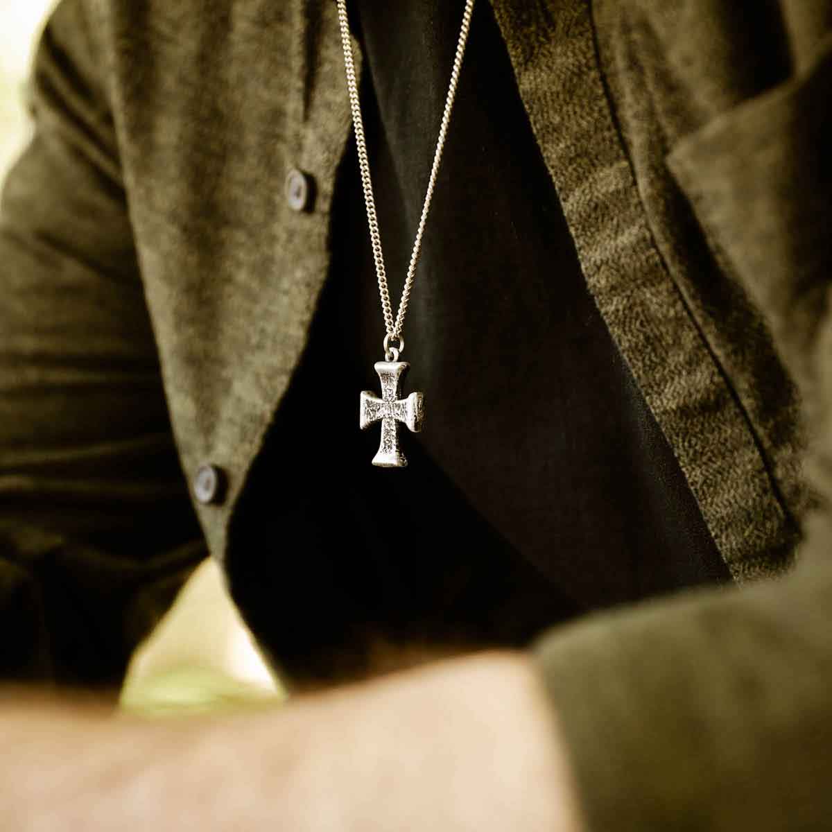 man wearing a sterling silver Flourish Cross Necklace