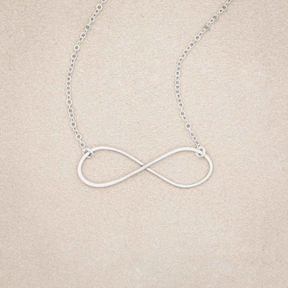 A sterling silver Forever, For Always Infinity Necklace, on beige background