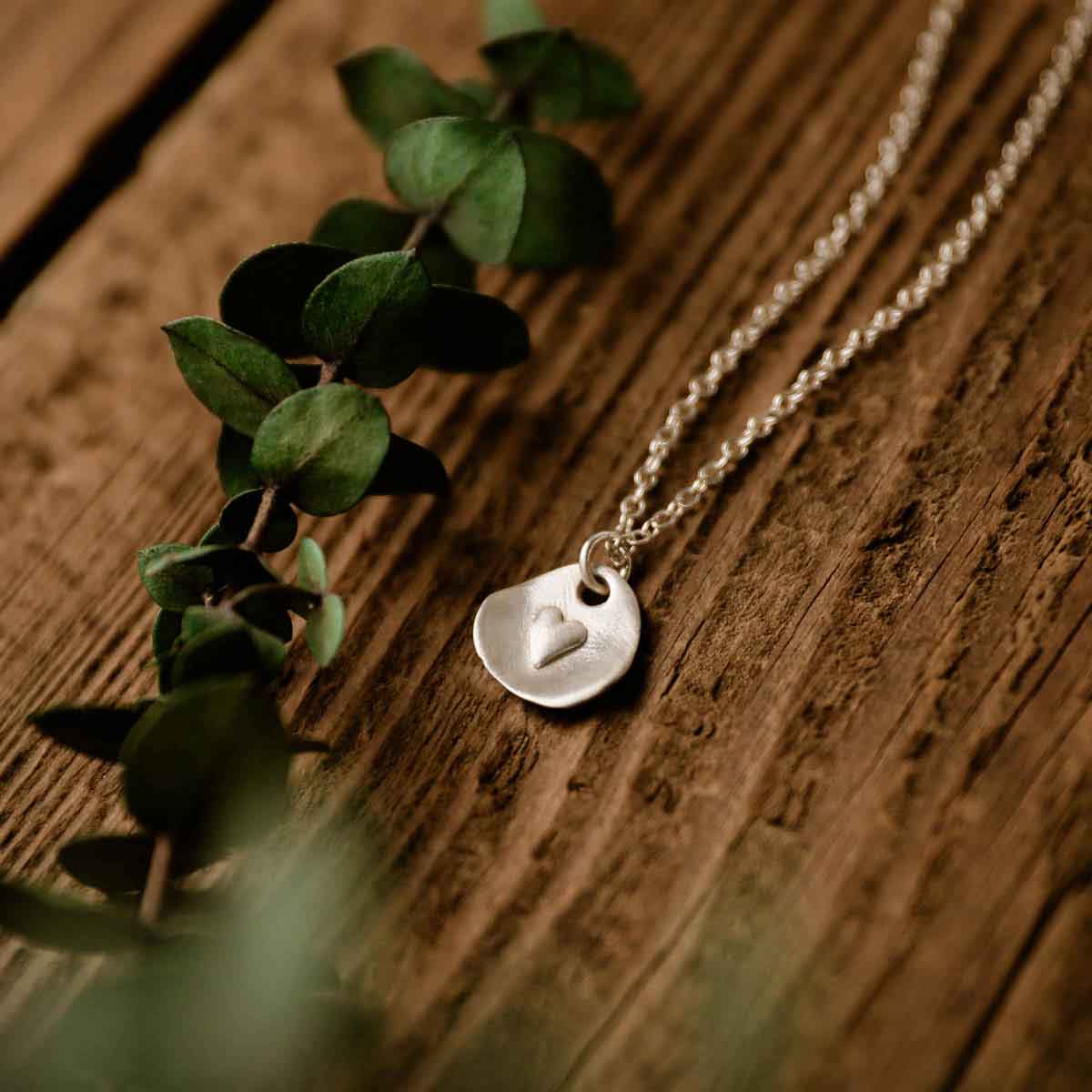 sterling silver full of love necklace with link chain on wood background