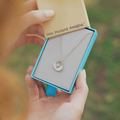 hand holding sterling silver full of love necklace with link chain in lisa leonard necklace box