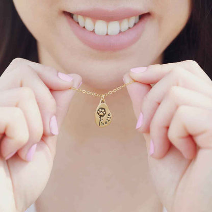 hand holding a Furry Footprint Flower Necklace