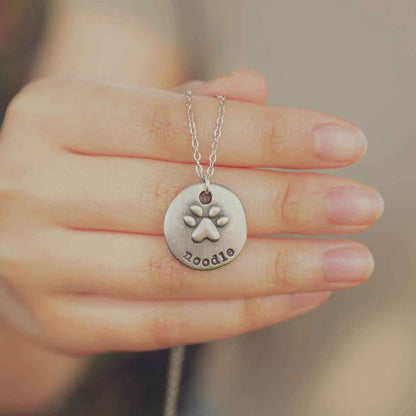 Girl wearing her Furry footprint necklace handcrafted in sterling silver with a paw engraved and personalized with a pet's name