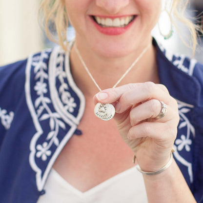 Mom wearing her Furry footprint necklace handcrafted in sterling silver with a paw engraved and personalized with a pet's name