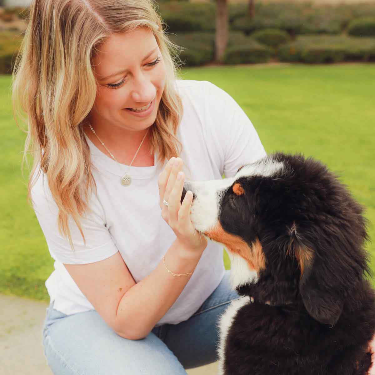 Girl wearing her Furry footprint necklace handcrafted in sterling silver with a paw engraved and personalized with a pet's name