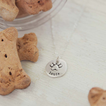 Girl wearing her Furry footprint necklace handcrafted in sterling silver with a paw engraved and personalized with a pet's name