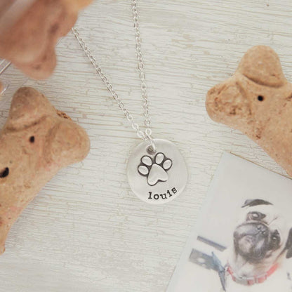 Furry footprint necklace handcrafted in sterling silver with a paw engraved and personalized with a pet's name