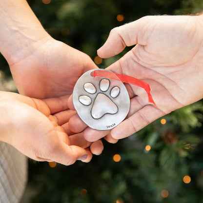 a pair of furry footprint ornament hand-molded and cast in fine pewter and personalized with a meaningful name