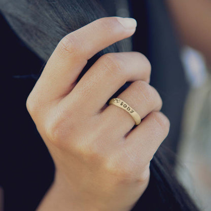 woman wearing her furry footprint 14k yellow gold stacking ring personalized with pet name