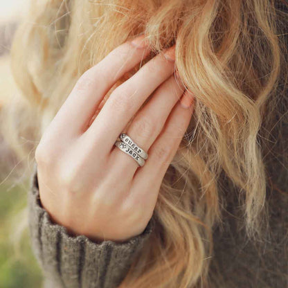 Woman wearing her furry footprint sterling silver stacking rings personalized with her pet names