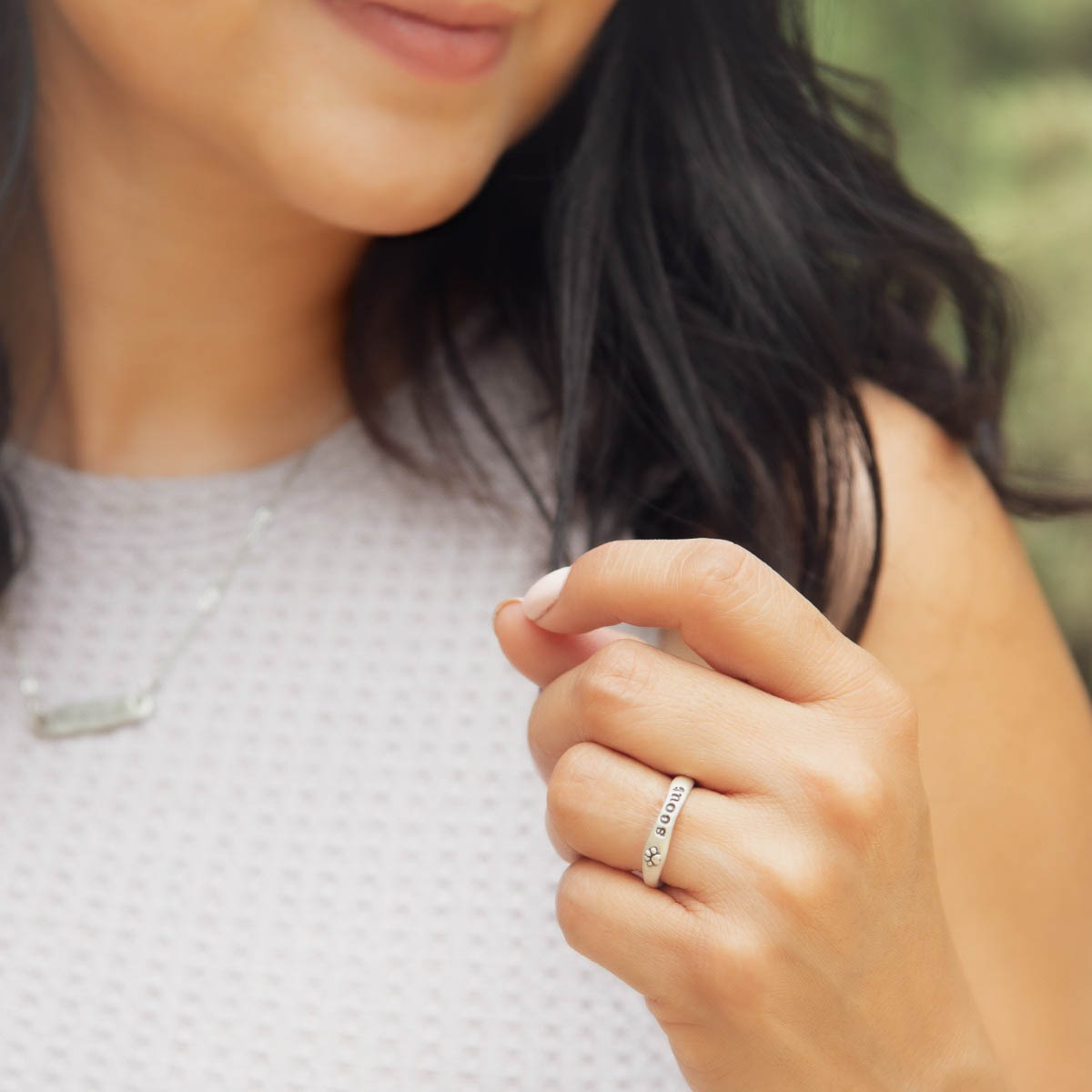 Woman wearing her furry footprint sterling silver stacking ring personalized with a pet name