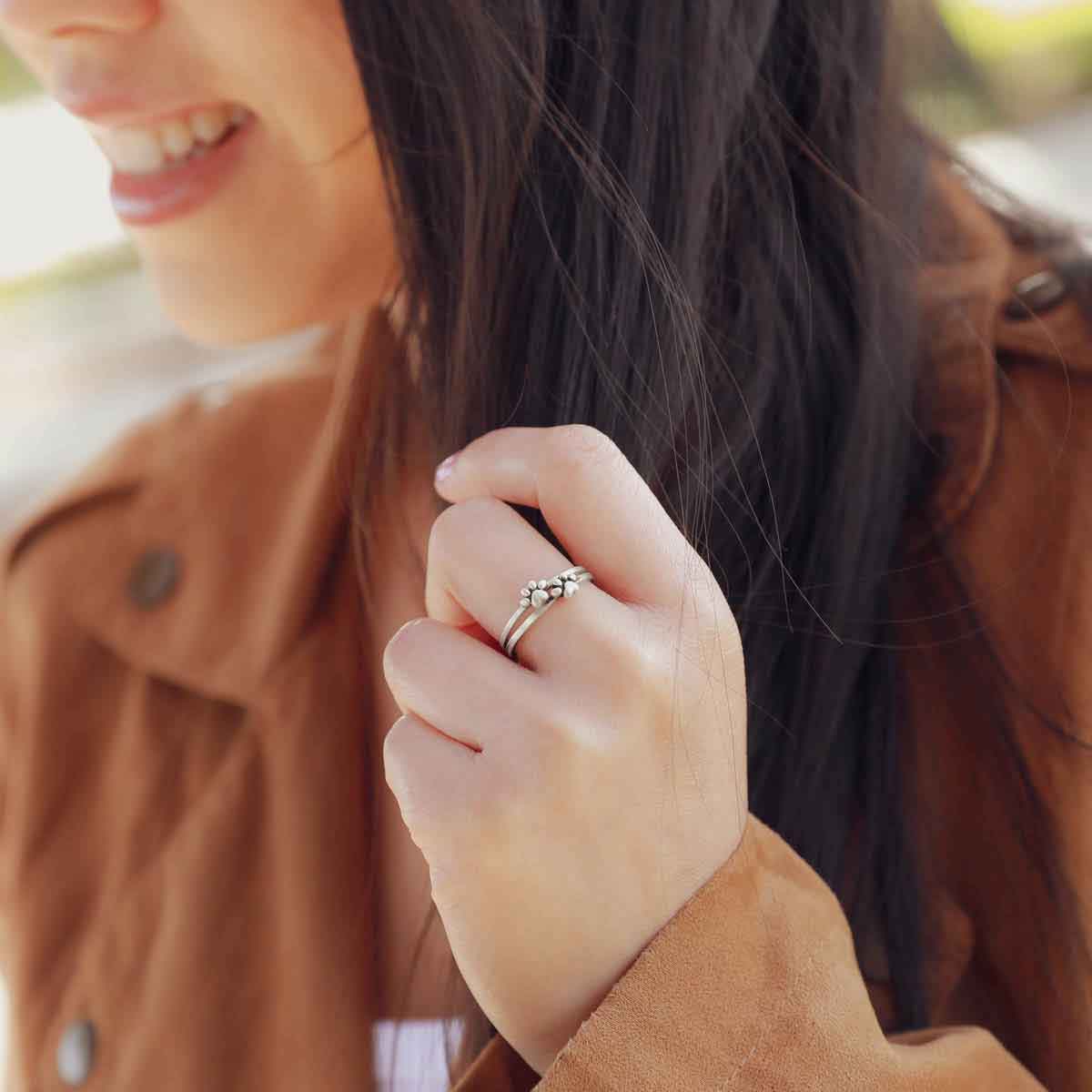 Girl wearing two stacked Furry Footprint Dainty Rings handcrafted in sterling silver