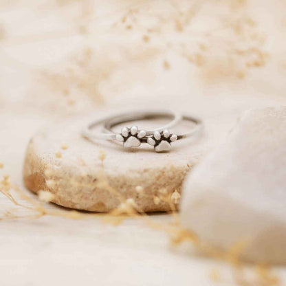 Girl wearing two stacked Furry Footprint Dainty Rings handcrafted in sterling silver