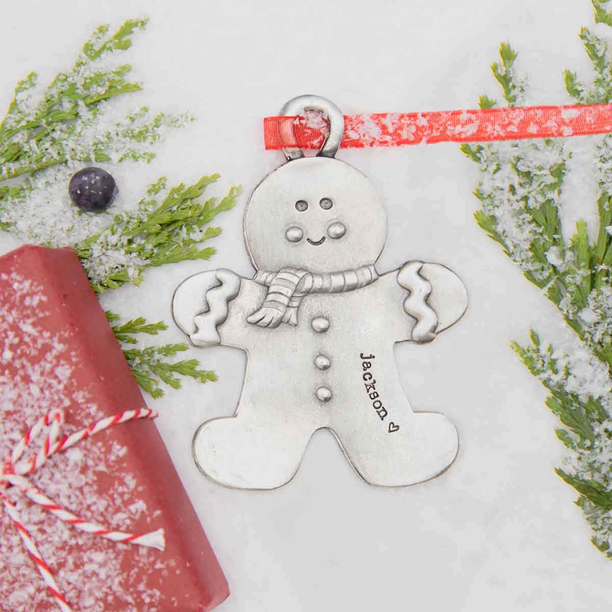 Gingerbread boy ornament  hand-molded and cast in fine pewter hung from a sheer red ribbon with a personalized word