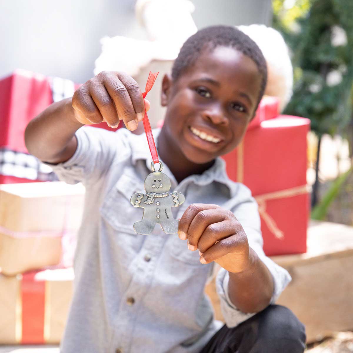 Gingerbread boy ornament  hand-molded and cast in fine pewter hung from a sheer red ribbon with a personalized word