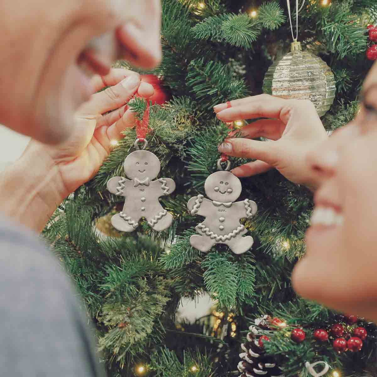 Gingerbread mom ornament hand-molded and cast in pewter with a personalized name being hung on a Christmas tree