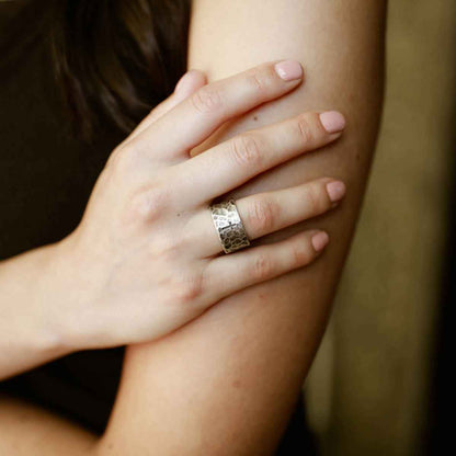 woman holding a blackened sterling silver Hammered Cross Adjustable Ring