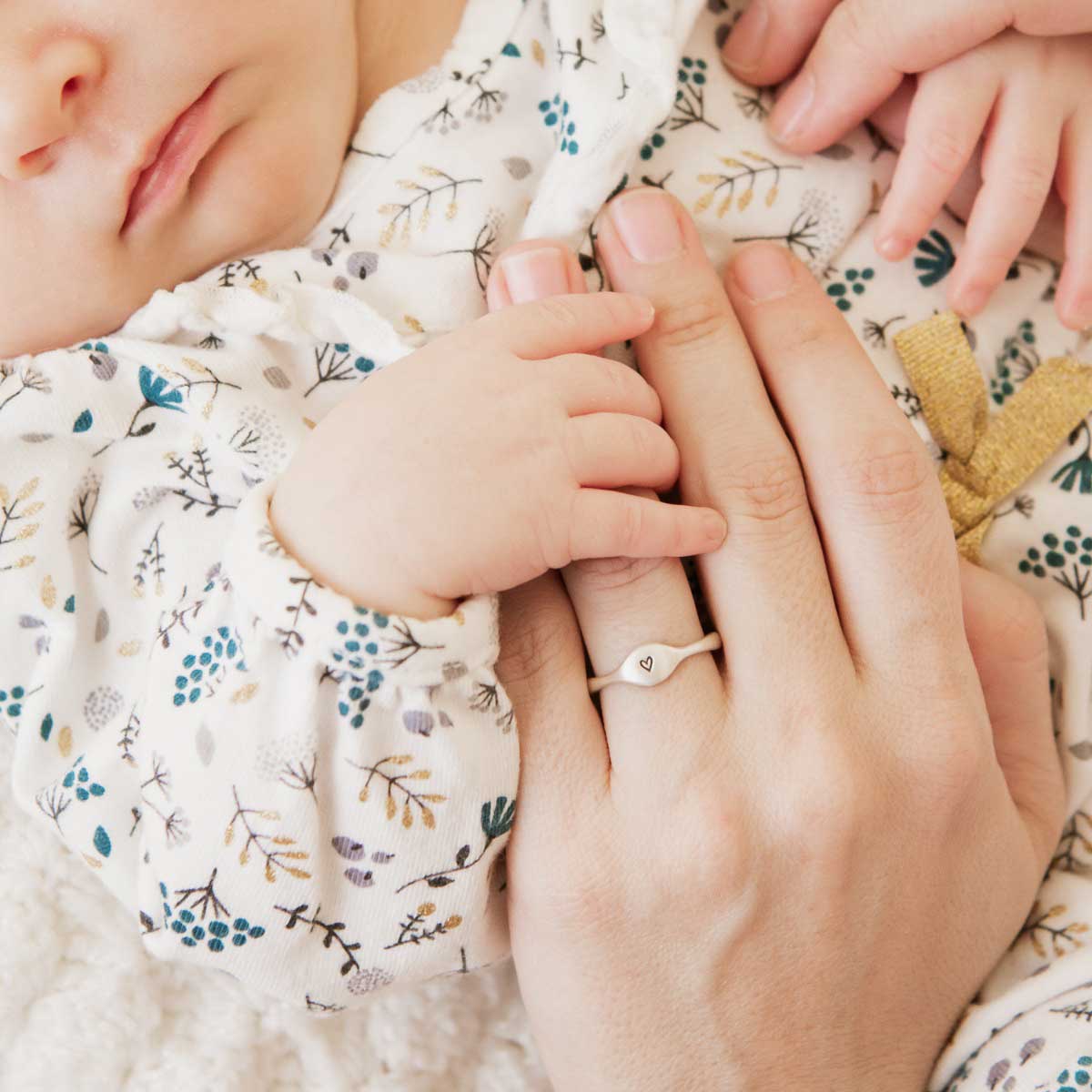 Mom wearing her Initial stacking ring handcrafted and cast in sterling silver then hand-stamped with an initial along with her children