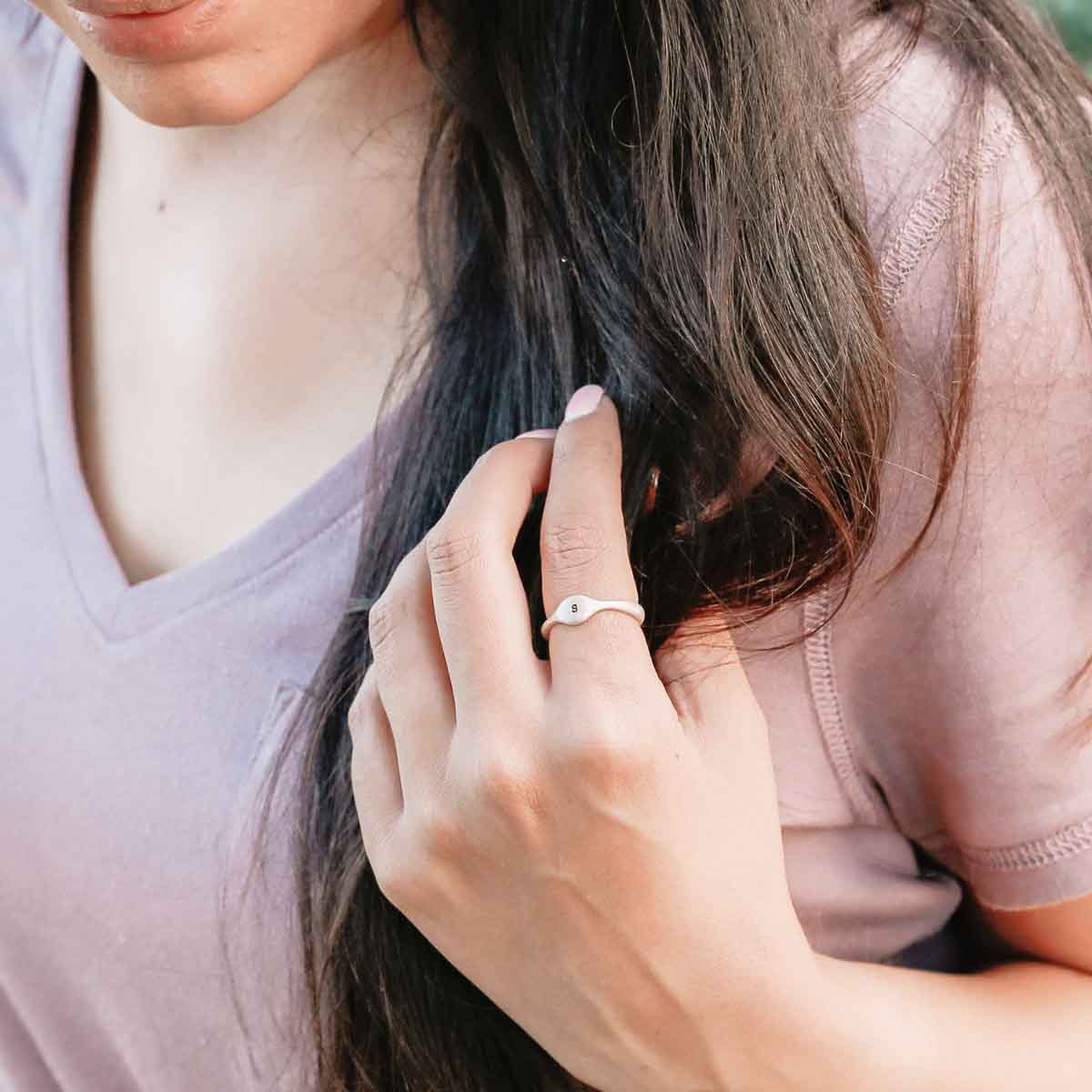 Girl wearing her Initial stacking ring handcrafted and cast in sterling silver then hand-stamped with an initial