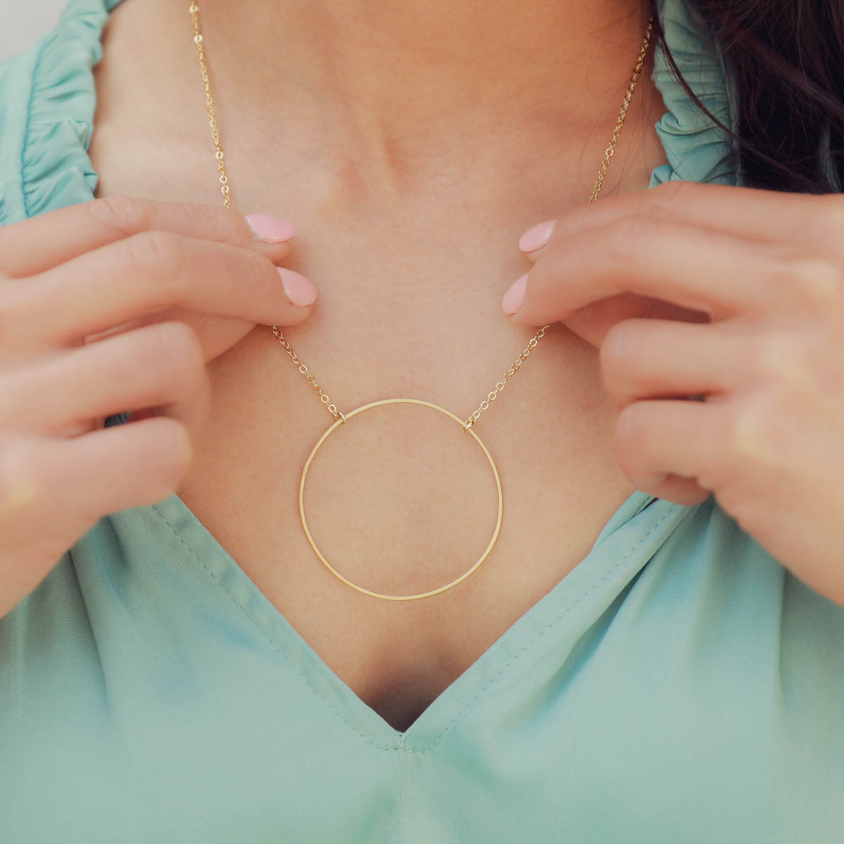 Woman wearing a gold filled It All Matters Circle Necklace in her kitchen