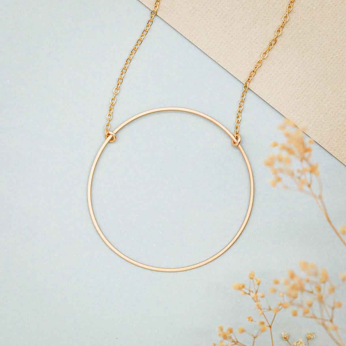 Woman holding a gold filled It All Matters Circle Necklace 
