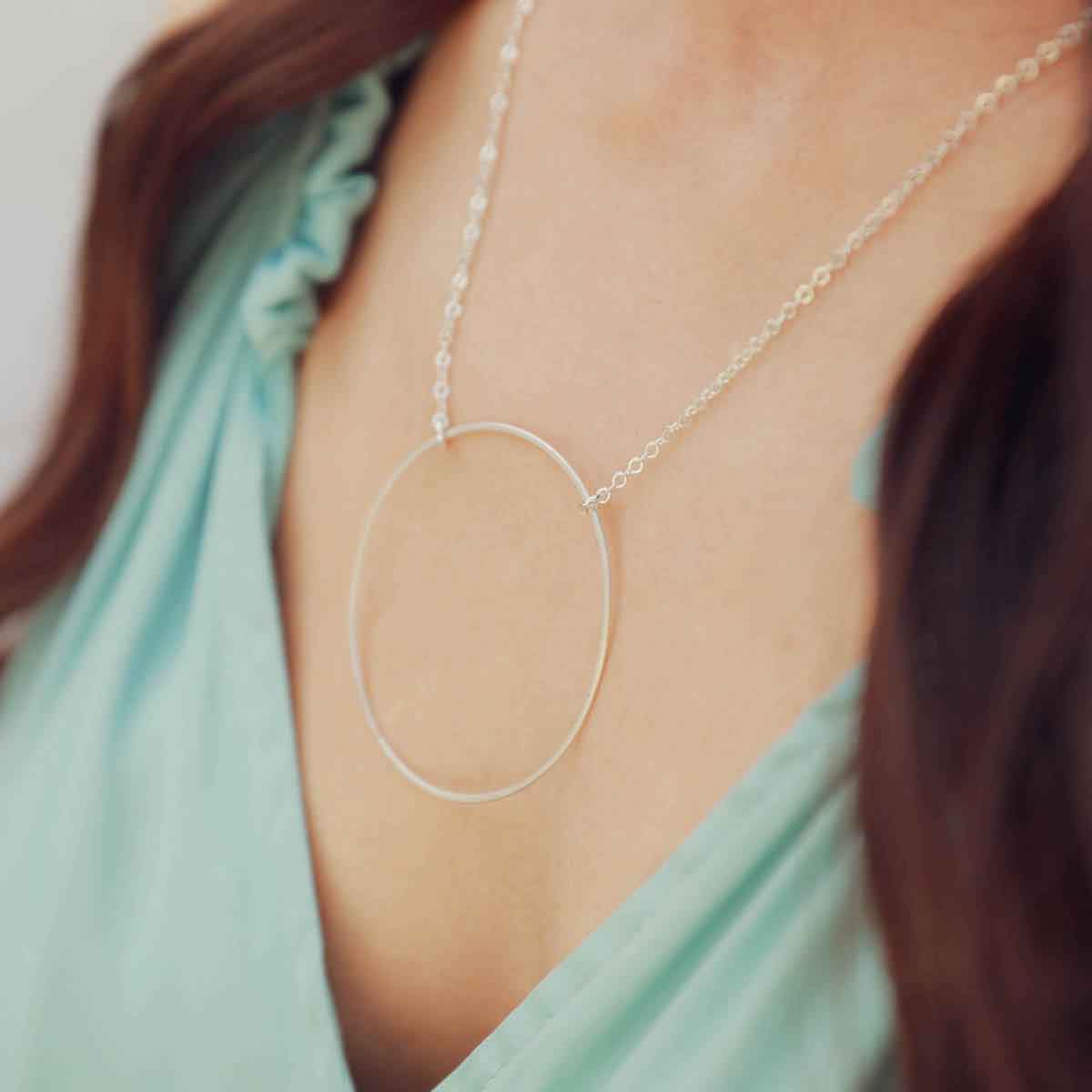 Hand holding a sterling silver It All Matters Circle Necklace