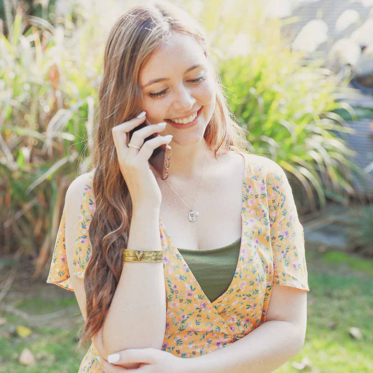 Girl wearing her January birth flower necklace handcrafted in sterling silver with a special birth month charm strung with a vintage freshwater pearl