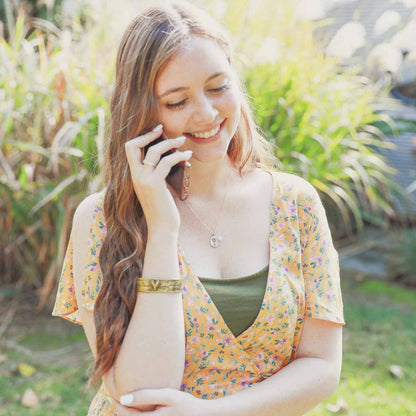 Girl wearing her January birth flower necklace handcrafted in sterling silver with a special birth month charm strung with a vintage freshwater pearl